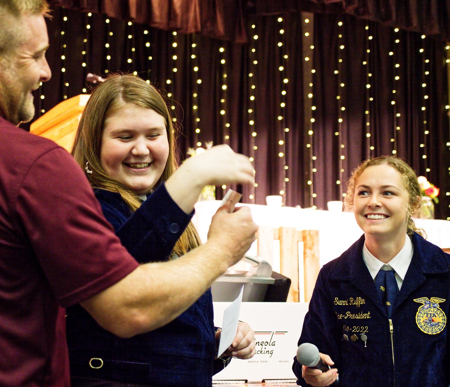 Damon Young tries to help Sydney VanCleave and Sunni Ruffin decipher the signature on one of the raffle tickets drawn. [more hay auction action]